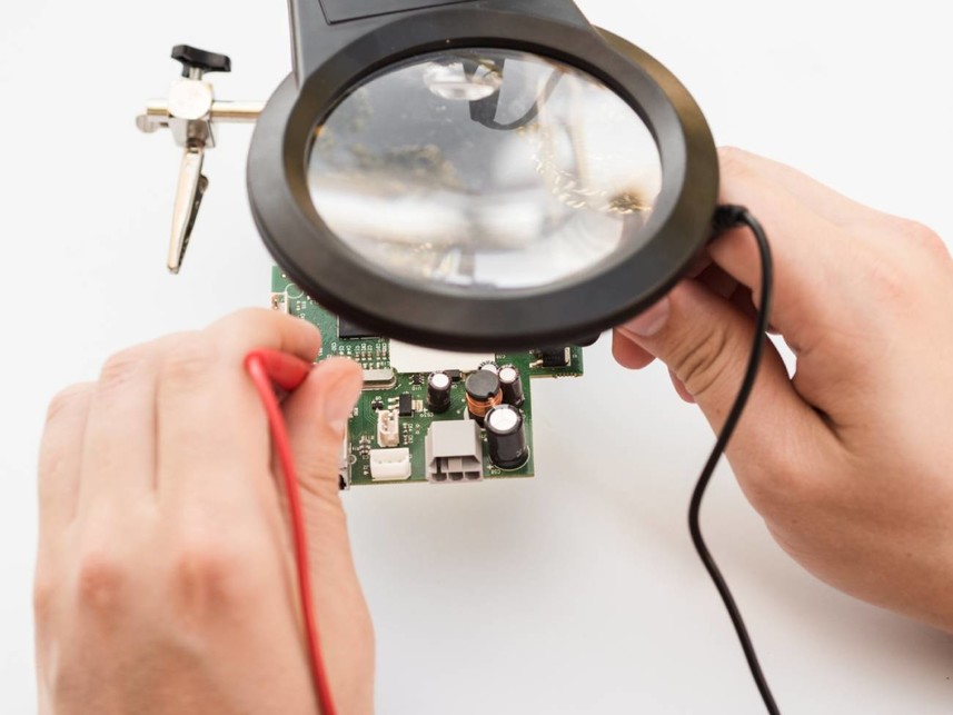 servicio tecnico reparando una placa de circuito electronico